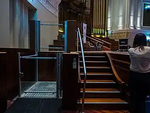 Indoor vertical platform lift to overcome stairs to a stage.