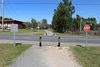 United States: An unmarked crossing with bollards keeping motor vehicles off the bike trail. (Douglas, Georgia)