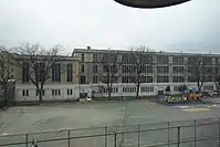 A schoolyard next to a playground (to the right, behind the fence)