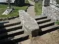 Coffin-shaped coffin rest with granite cattle grid (barrier=cattle_grid) on either side Sarah Charlesworth / Granite cattlegrid at the entrance to St Levan churchyard (Cornwall)
