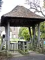 Lych gate with wooden coffin rest in England Trish Steel, CC BY-SA 2.0, via Wikimedia Commons