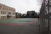 A schoolyard with basketball hoops and a painted running track