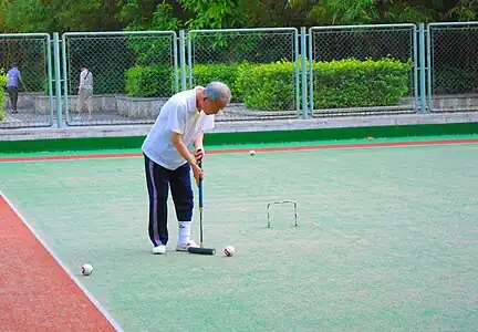 People playing gateball or a variant in Haikou People's Park, Haikou City, Hainan Province, China