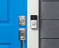 Photo of a doorbell with built-in camera facing away from the adjacent door