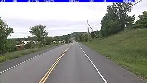 A 2-lane rural trunk road with yellow center-line and white fog lines.