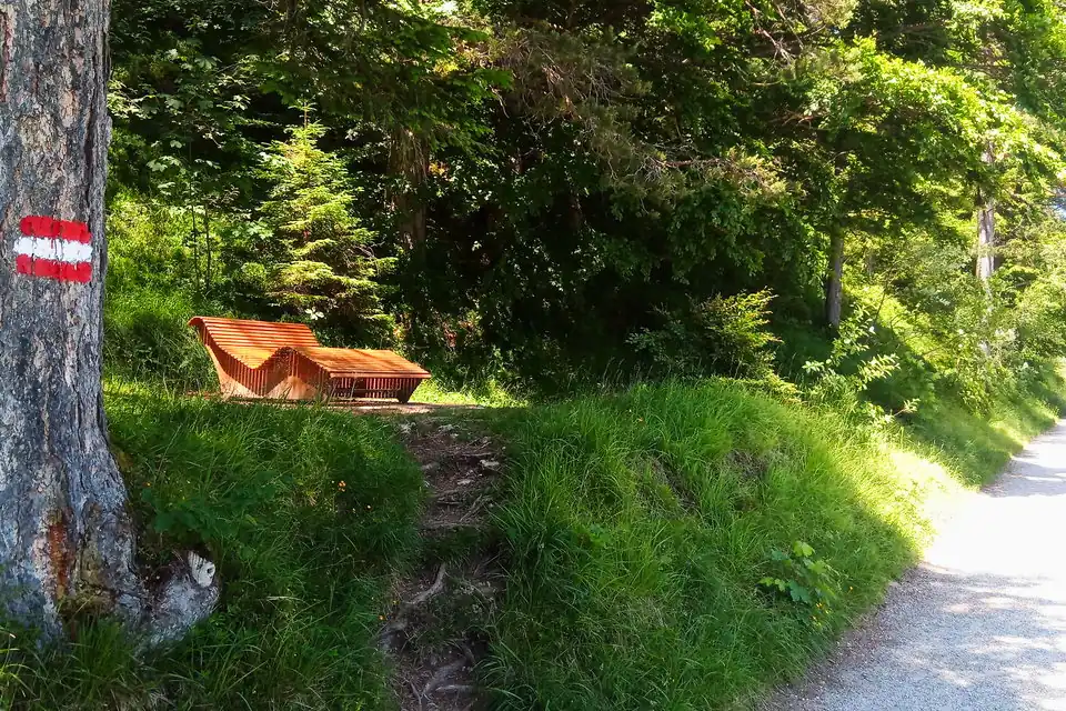A wave lounger of seats=3 next to a hiking path