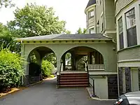 Крыша, построенная над входом. Слева находится проход, по которому могут проходить люди, посередине — крытый вход в расположение двери, справа — дом.