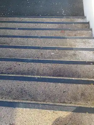 un escalier avec une bande contrastée sur chaque bordure de marche