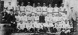 Black and white newspaper clipping depicting baseball players in uniform and several men in suits