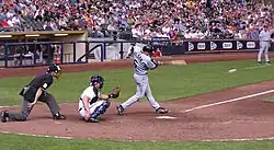 Dan Wilson following through after batting, with the ball a white blur on the right