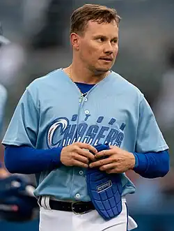 Diego Castillo in a light blue Omaha Storm Chasers uniform, removing his sliding mitt