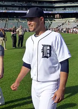 Eugenio Suárez, smiling in a white Detroit Tigers uniform on a baseball field