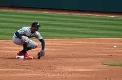 Jonathan Schoop of the Minnesota Twins, crouching on second base and attempting to catch a ball thrown from the right