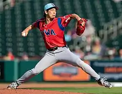 Kenta Maeda, mid-pitching motion in a red Iowa Cubs jersey