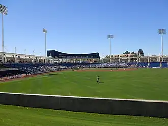 A baseball game being played on a green field surrounded by blue stadium seats