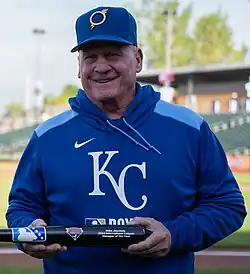 Mike Jirschele receiving his 2024 Manager of the Year award, wearing an Omaha Storm Chasers hat and blue Kansas City Royals sweatshirt