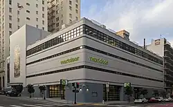 A Streamline Moderne building on a street corner in an urban area