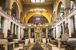 Interior courtyard view of the Egyptian Museum showing visitors and stone artefacts