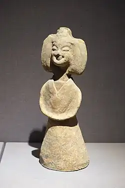 Earthenware Nanjing female figure wearing youren upper garment and a skirt with a straight-necked undergarment; d. Southern dynasty.[91]