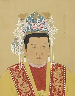 Empress Ma wears red and yellow robes and a crown decorated with pearls and gold dragons.
