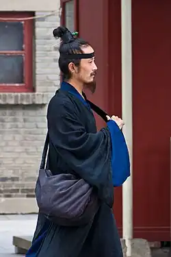 A Taoist man with a topknot and cross-collared jiaoling youren robe.