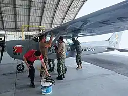 Colour photo of people working on an aircraft on the ground