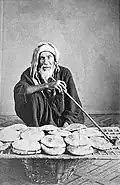 An elderly Egyptian vendor selling bread, 1870s