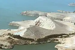 Aerial view of the hill covering the rear of the Abu Simbel temples in 1969. The smaller of the two temporary holding storage areas used during relocation of the temple can be seen in the background.