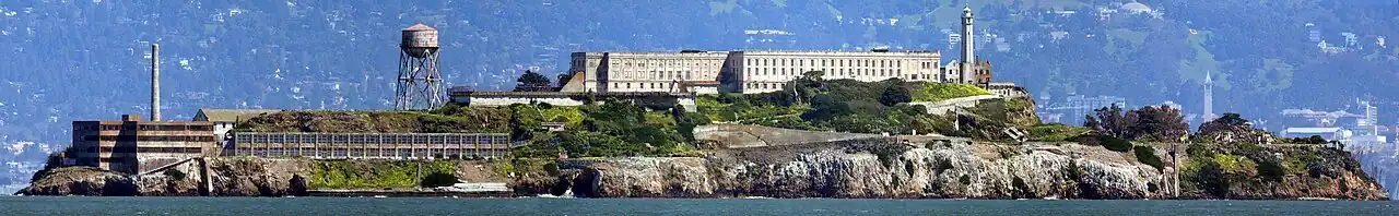 A panorama of Alcatraz as viewed from San Francisco Bay, facing east. Sather Tower and UC Berkeley are visible in the background on the right.