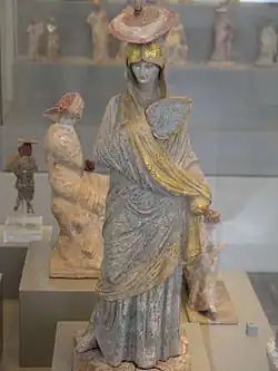 Ancient Greek statue of a lady with blue and gilt garment, a fan and a sun hat, from Tanagra, c. 325–300 BC