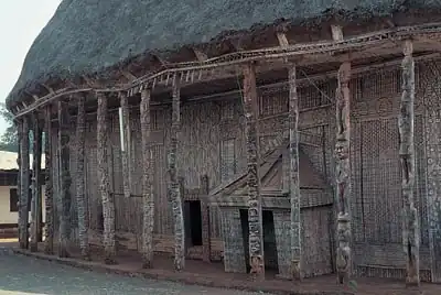 Traditional Bamileke architecture, main hall of the Bandjoun palace in Cameroon, with decoratively carved wooden columns and doorway, unknown architect, unknown date