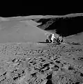 Lunar landscape with man leaning over rover