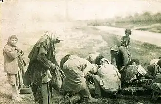 Armenian refugees collected near the body of a dead horse at Deir ez-Zor, during the Armenian genocide