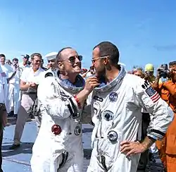 Still in their space suits. Cooper has an eight-day growth of beard.