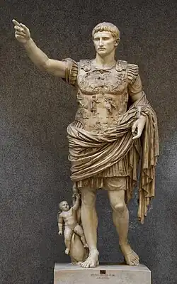 This image shows the sculpture Augustus of Prima Porta, a full body portrait of the Roman Emperor Augustus. He is depicted wearing armor that shows the story of one of his diplomatic gains as well as with a small cherub and dolphin by his right leg.