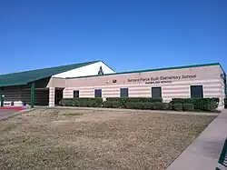 A school building with "Barbara Pierce Bush Elementary School: Exemplary School" lettered on the wall
