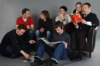 Members of Belle and Sebastian, pictured sometime between 2005 and 2006. Left to right: Mick Cooke, Richard Colburn, Bobby Kildea, Chris Geddes, Stevie Jackson, Sarah Martin, Stuart Murdoch