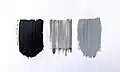 Black paint alongside two shades of gray paint