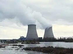 Nuclear power plant in Cattenom, France four large cooling towers expelling white water vapour against a blue sky