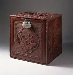 Japanese chest with cartouche showing figures on donkeys in a landscape; 1750–1800; carved red lacquer on wood core with metal fittings and jade lock; 30.64 x 30.16 x 12.7&nbsp;cm; Los Angeles County Museum of Art (USA)