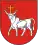 A coat of arms depicting a white bull with an angry expression and a golden cross protruding from its head all on a red background