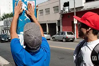 A person putting up a sticker in São Paulo. 2009