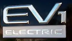 Badging with the text "EV1" in large, metallic, and stylized letters. Below that, there is the word "ELECTRIC" in smaller, white, uppercase letters.