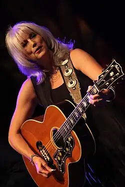 Singer Emmylou Harris playing a guitar