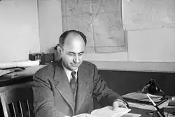 Enrico Fermi sits at his desk reading.