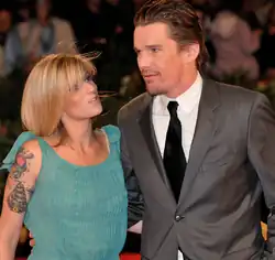 Hawke, wearing a suit and tie, next to his wife, wearing a green dress