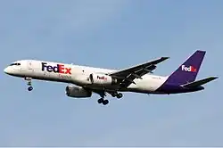 Side view of a white and purple twin-engine jet in flight