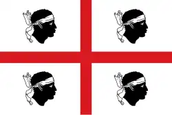 The flag of Sardinia, shows a Saint George's Cross on a white field, surrounded by four black heads, known as the Four Moors