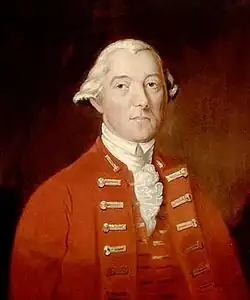 A half-height portrait of Carleton. He wears a red coat with vest, over a white shirt with ruffles. His white hair is drawn back, and he faces front with a neutral expression.
