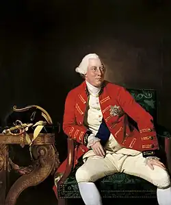 Three-quarter length seated portrait of a clean-shaven George with a fleshy face and white eyebrows wearing a powdered wig.